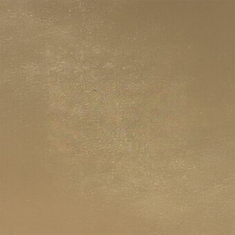 Muted gold textured surface with a matte finish, displaying granular quality and subtle tonal variations in a uniformly lit setting.